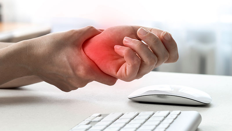 Person suffering from carpal tunnel syndrome in need of a Ponderay Chiropractor at By Design Chiropractic