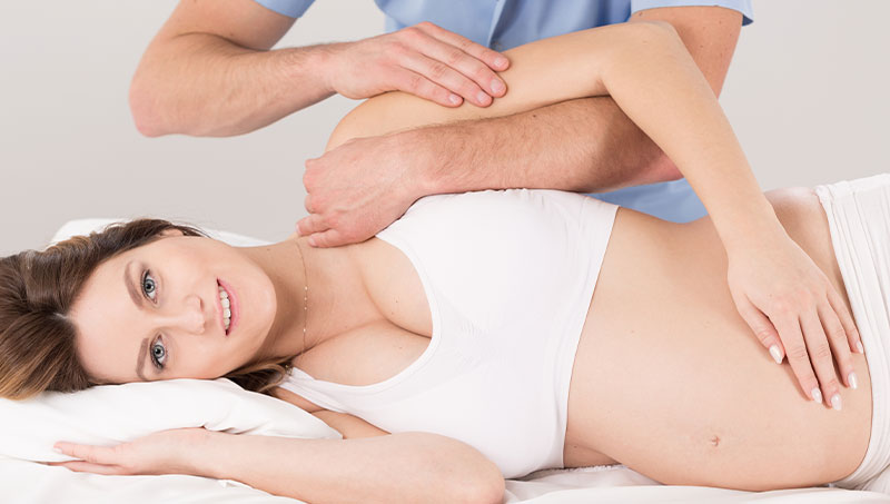 Pregnant patient reci=eiving an adjustment from a Ponderay Chiropractor at By Design Chiropractic