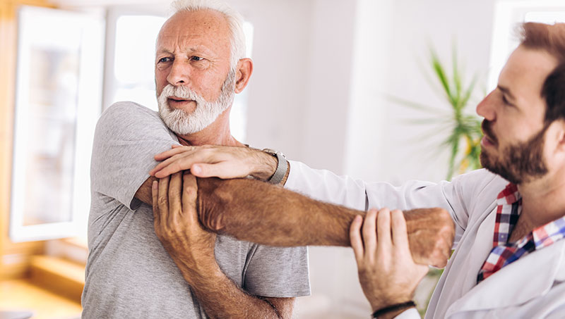 Senior patient receiving a shoulder ajustment from a Ponderay Chiropractor at By Design Chiropractic