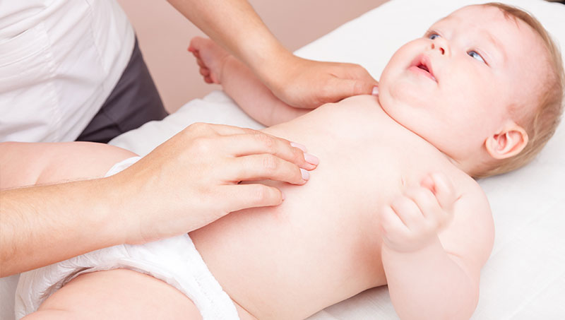Infant being adjusted for colic by a Ponderay Chiropractor at By Design Chiropractic