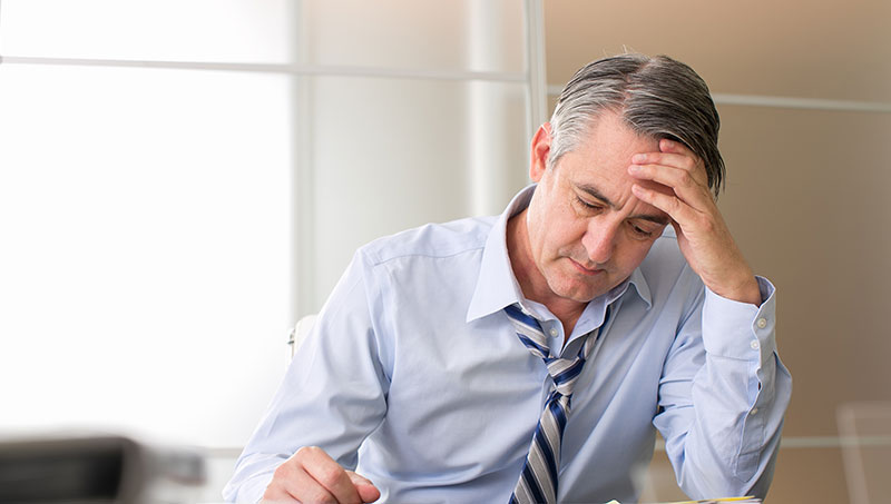 Man suffering from chronic stress in need of a Ponderay Chiropractor at By Design Chiropractic