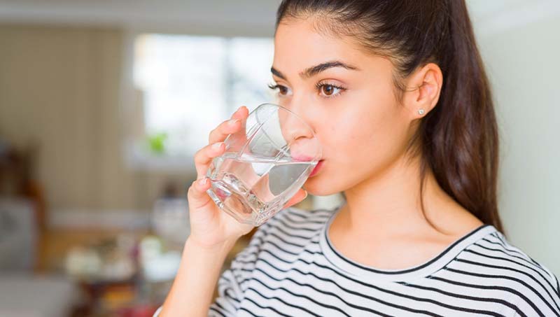 Woman drinking more water following the advice of a Ponderay Chiropractor at By Design Chiropractic