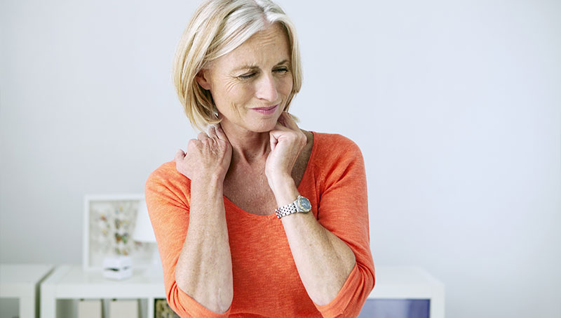 Woman suffering from neck and shoulder pain in need of a Ponderay Chiropractor at By Design Chiropractic