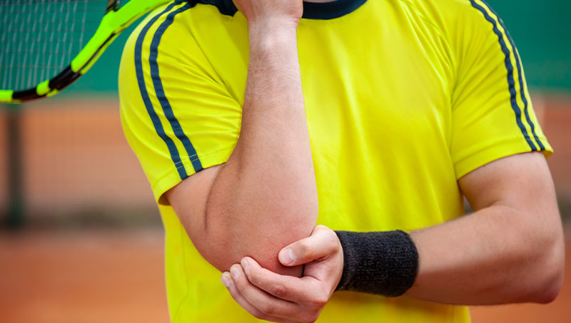Man suffering from tennis elbow in need of a Ponderay Chiropractor at By Design Chiropractic