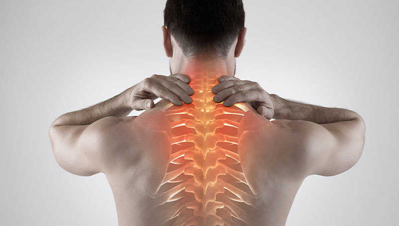 Man suffering from upper back pain in need of a Ponderay Chiropractor at By Design Chiropractic