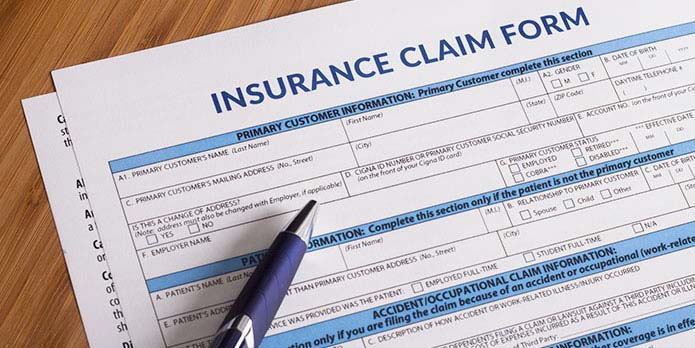 By Design Chiropractic filling out insurance cliam forms for patients